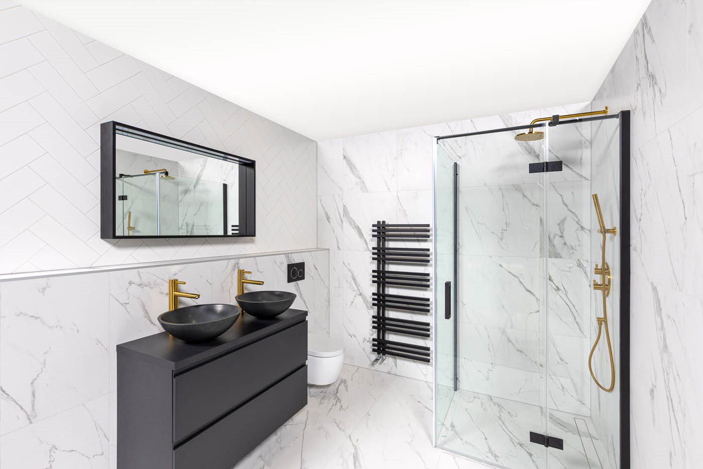 Shower drain installation: Shower drain with white marble effect tiles and gold taps.