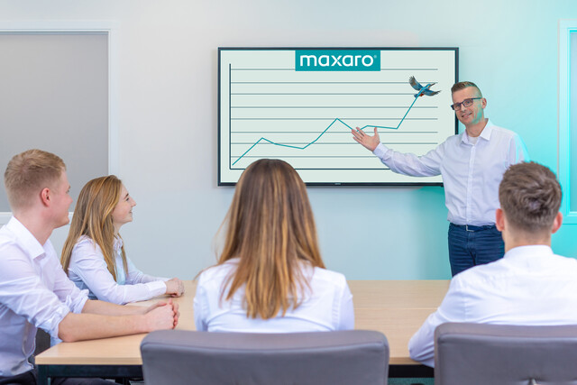 Business presentation in a meeting room with a white background and a monitor with a graph, no bathroom-related product visible.