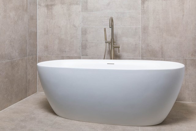 Wit vrijstaand ovale badkuip van keramiek, minimalistisch design, perfect voor een moderne badkamer met stijlvolle uitstraling.