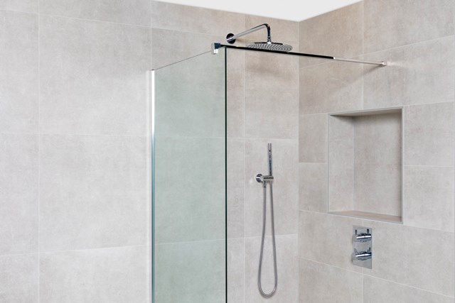 Glass walk-in shower with matte black rain shower and handheld shower, modern design, ideal for minimalist bathrooms.