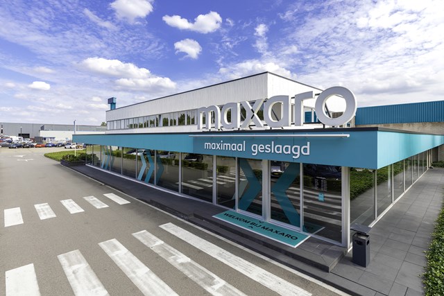 Modern storefront with blue exterior and "Makro" facade, under a clear sky; no specific bathroom product visible.