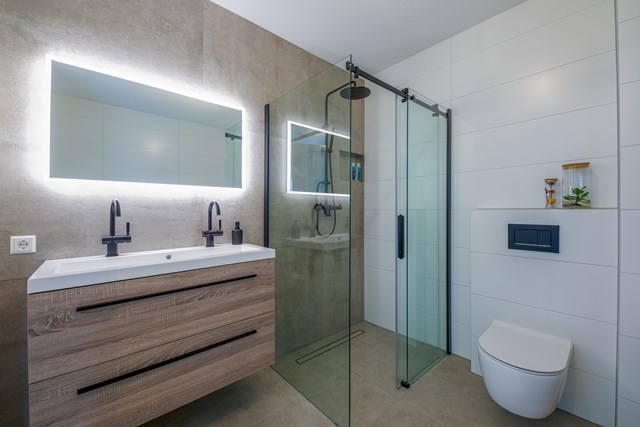 Moderne Badezimmer mit Holz-Waschtisch, LED-Spiegel, Glas-Duschwand und Wand-WC; stilvolle und luxuriöse Ausführung.