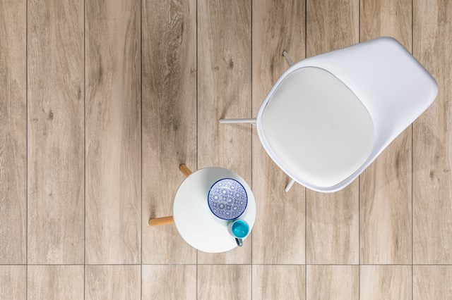 Witte kunststof prullenbak met deksel op houten badkamertegels, inclusief bijpassende pedaalemmer met moderne look.