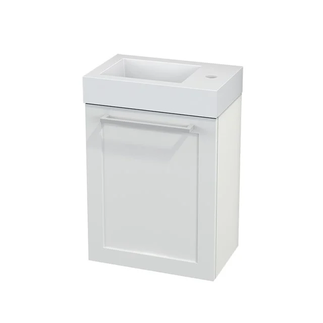 Weißes Badezimmermöbel mit integriertem Waschbecken, kompakte Form, klassische Paneeltüren und Stauraum für kleine Bäder.